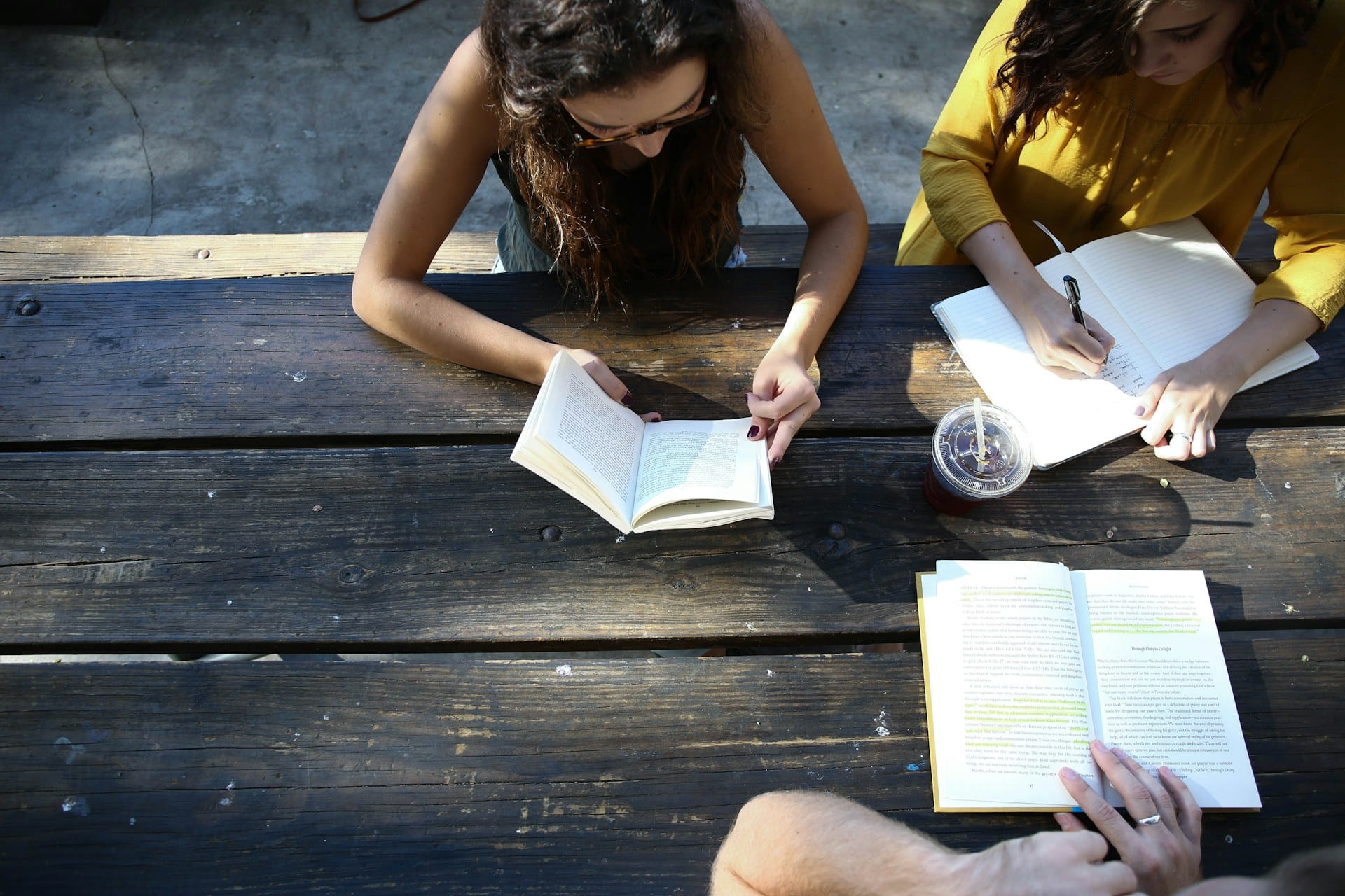 Friends studying the Bible together around a wooden table
