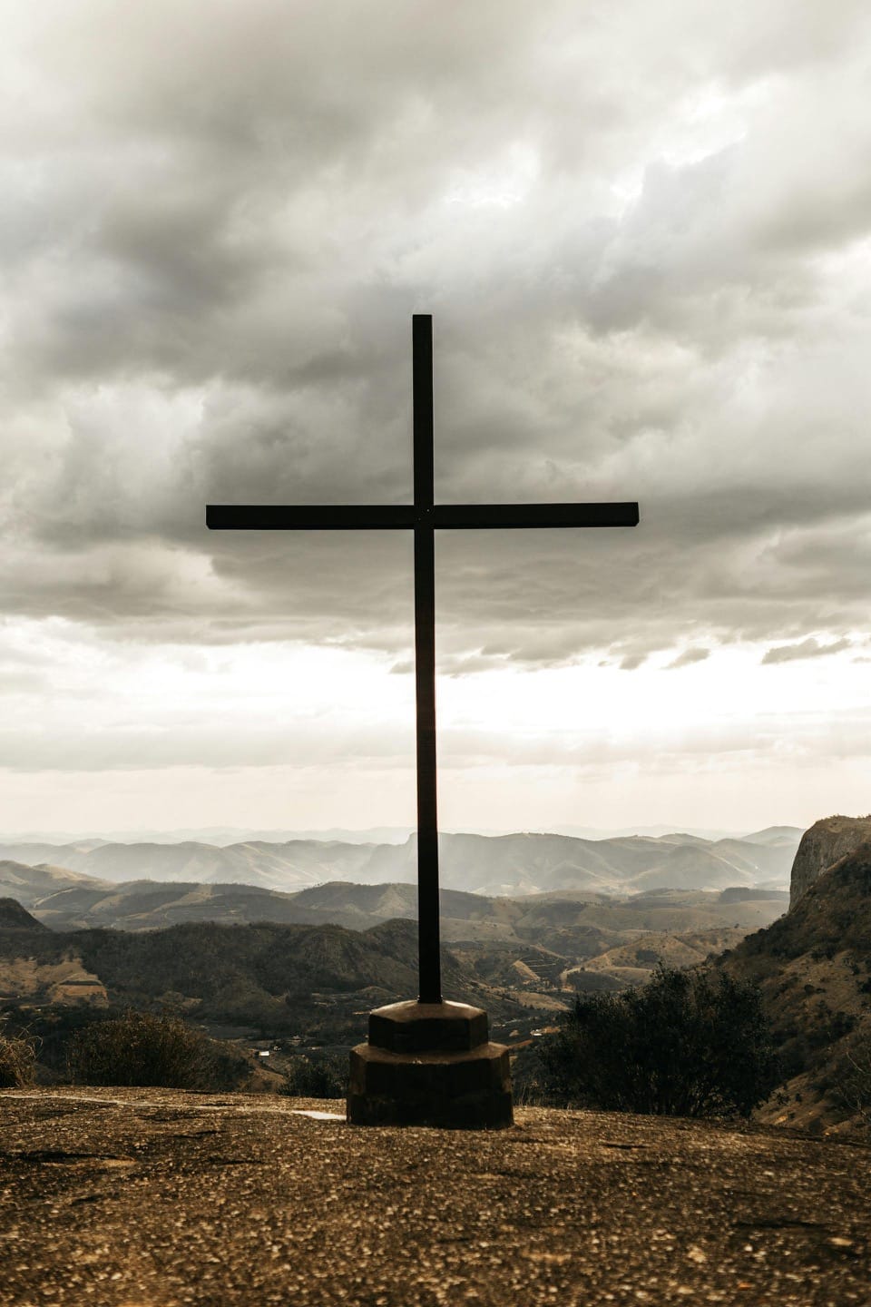 Cross on a scenic mountain with expansive landscape view